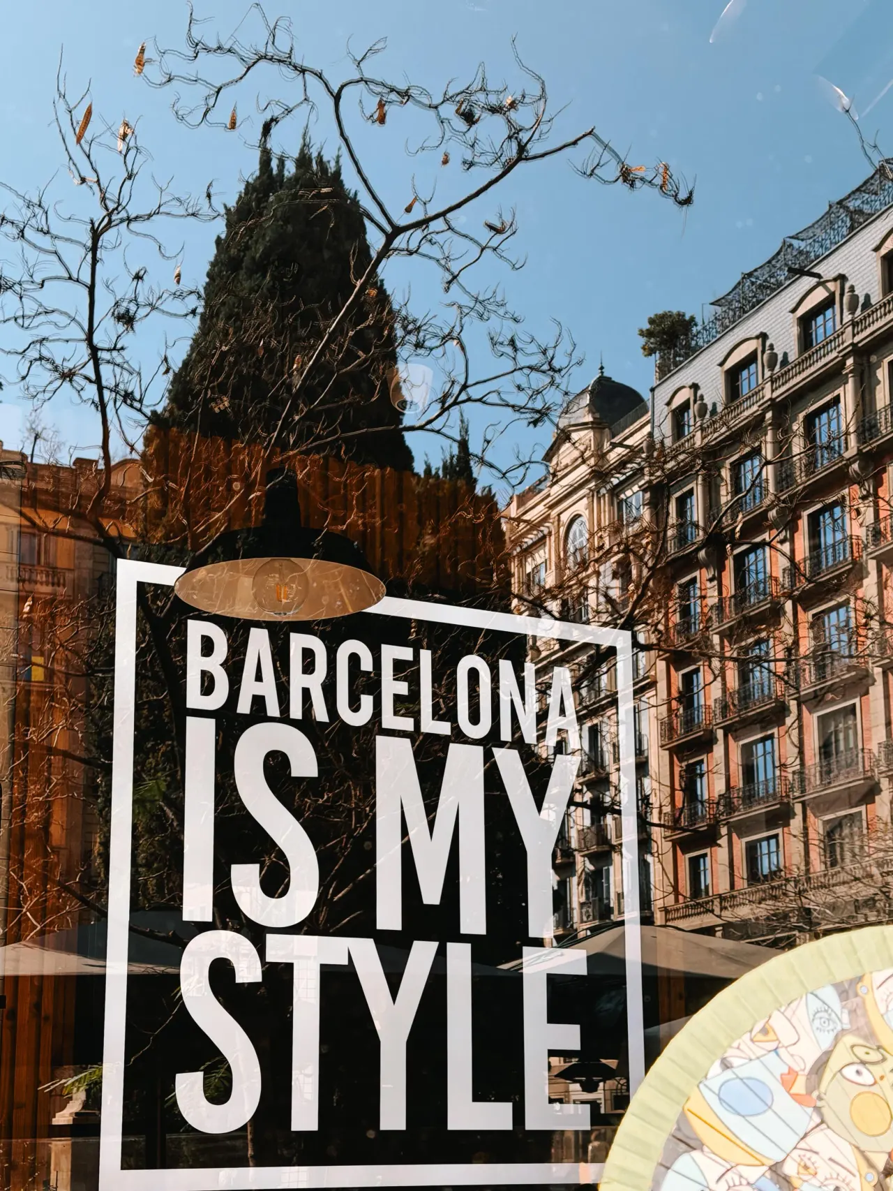 'Barcelona is my style' shop window reflecting an Eixample facade